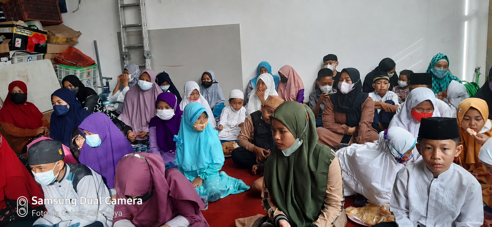 Anak-anak dan pendamping berkumpul bersama di atas karpet merah dalam kegiatan yayasan.