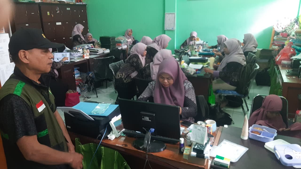 Relawan yayasan berbincang dengan petugas di ruang kerja sekolah.
